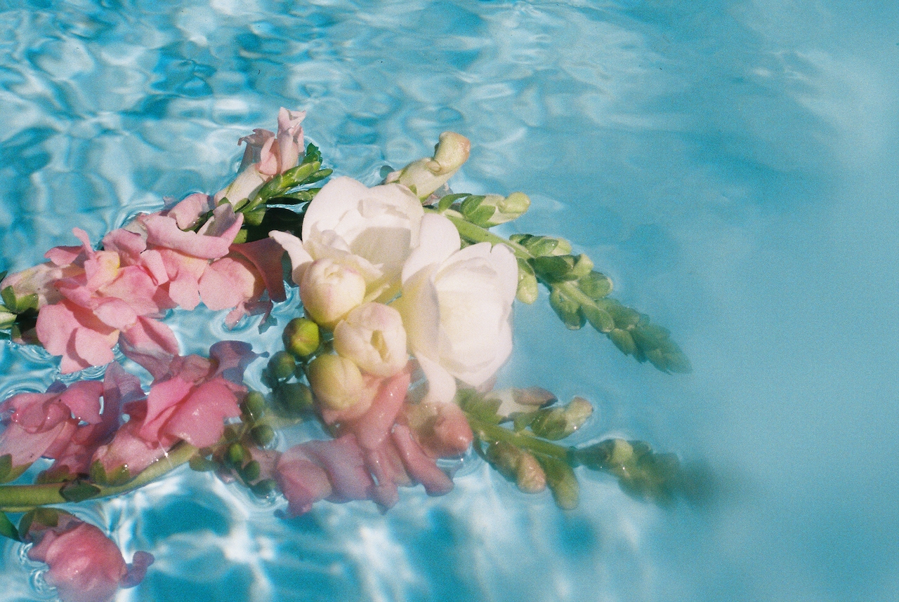 A bridal bouquet floats in a pool on a Showit website.