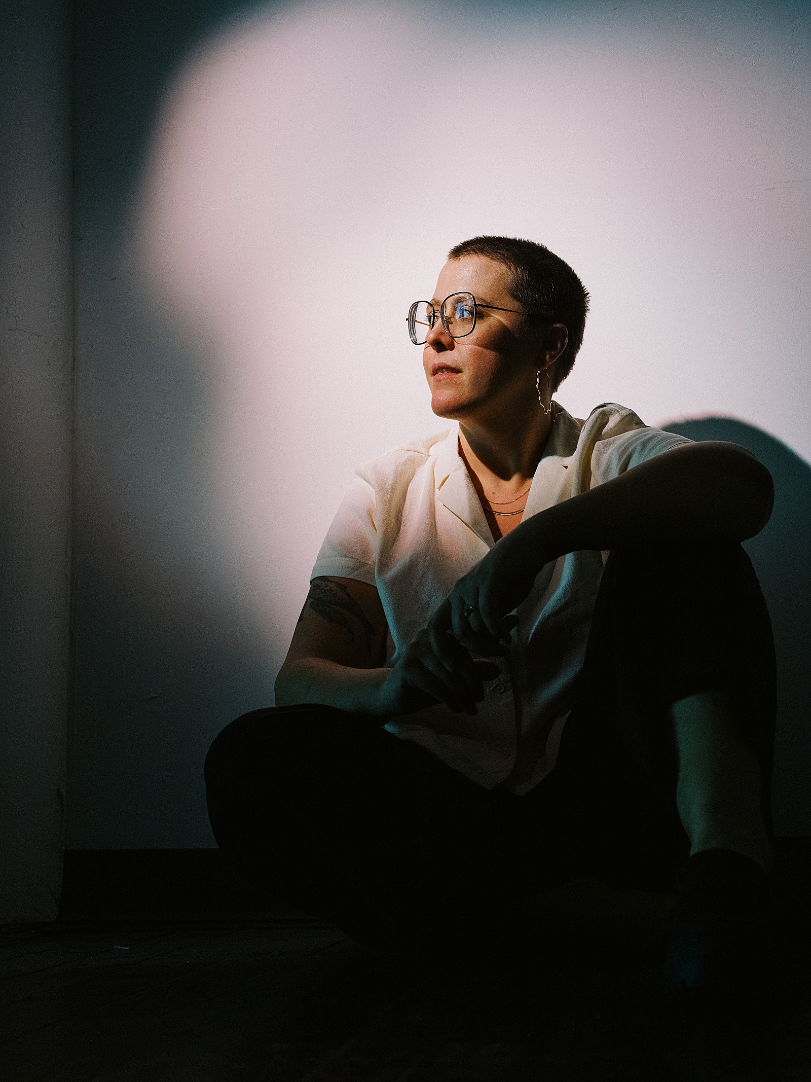 An SEO copywriter sits with her back to a wall in a Philadelphia photography studio.