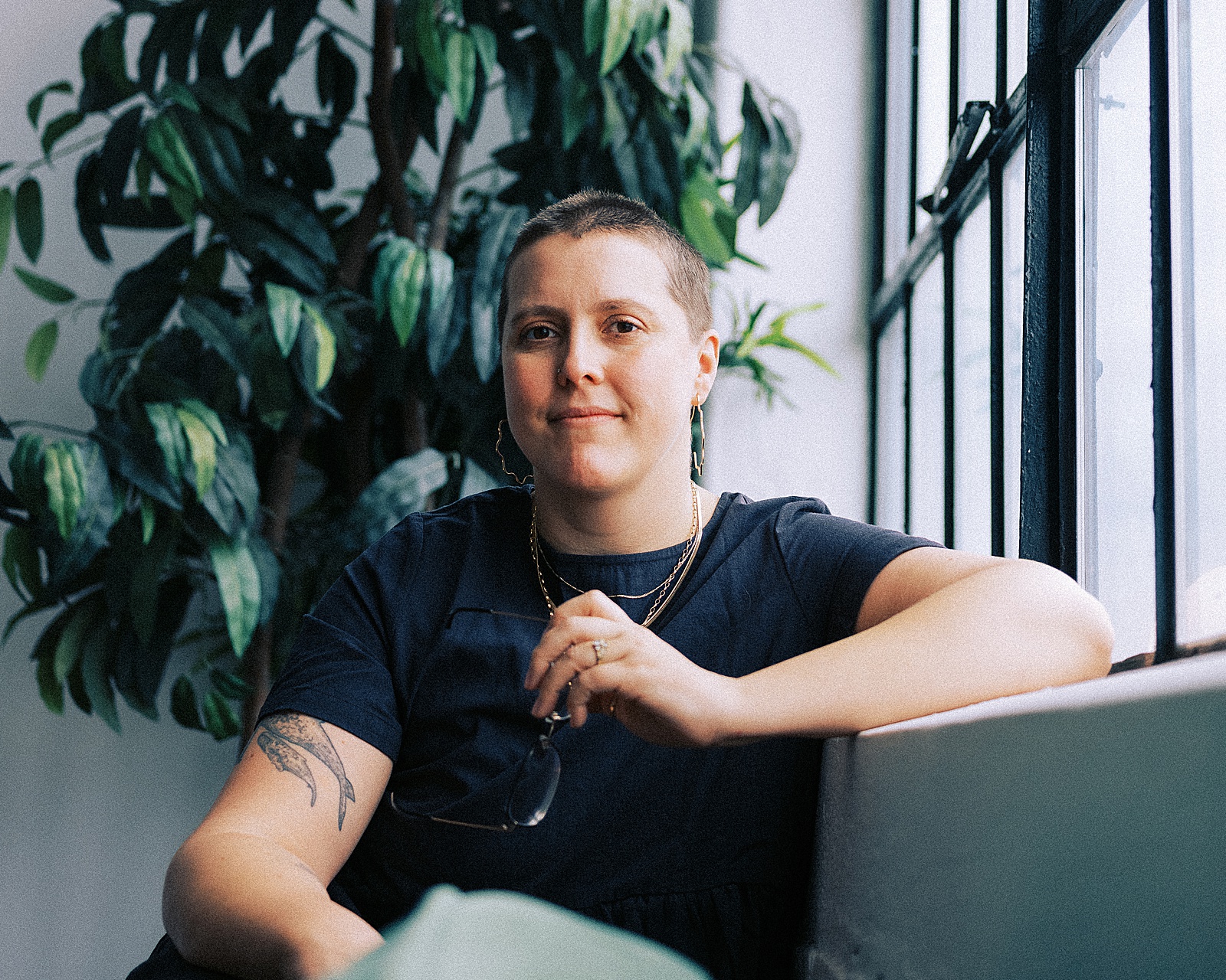An SEO copywriter leans on a windowsill.